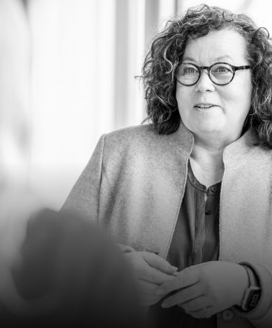 Eva Weber auf einer Bühne vor dunklem Hintergrund.