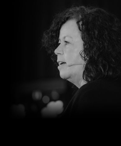 Eva Weber auf einer Bühne vor dunklem Hintergrund.